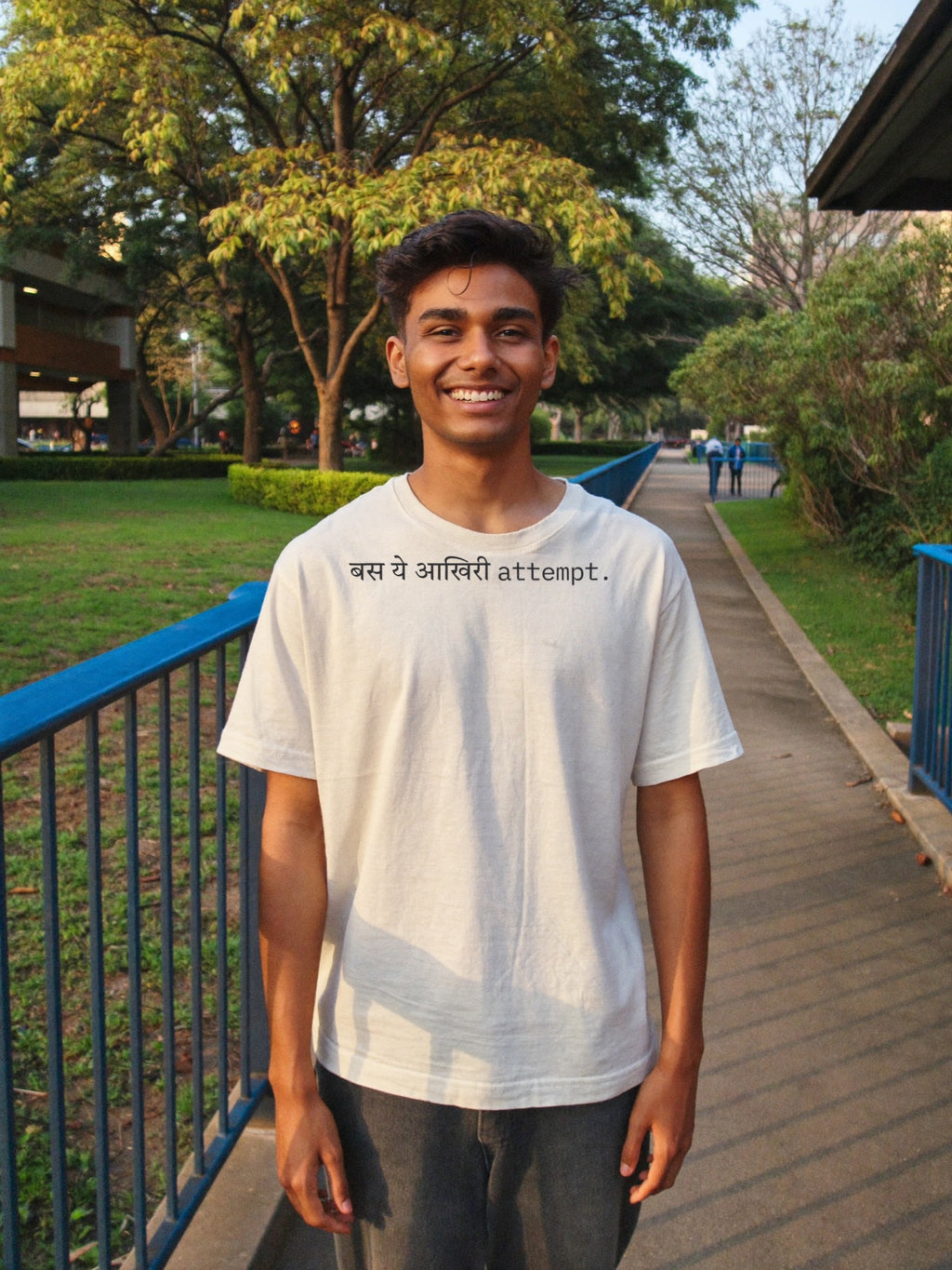 Man wearing the “बस ये आखिरी attempt.” Hindi text t-shirt in off white by Halant, campus