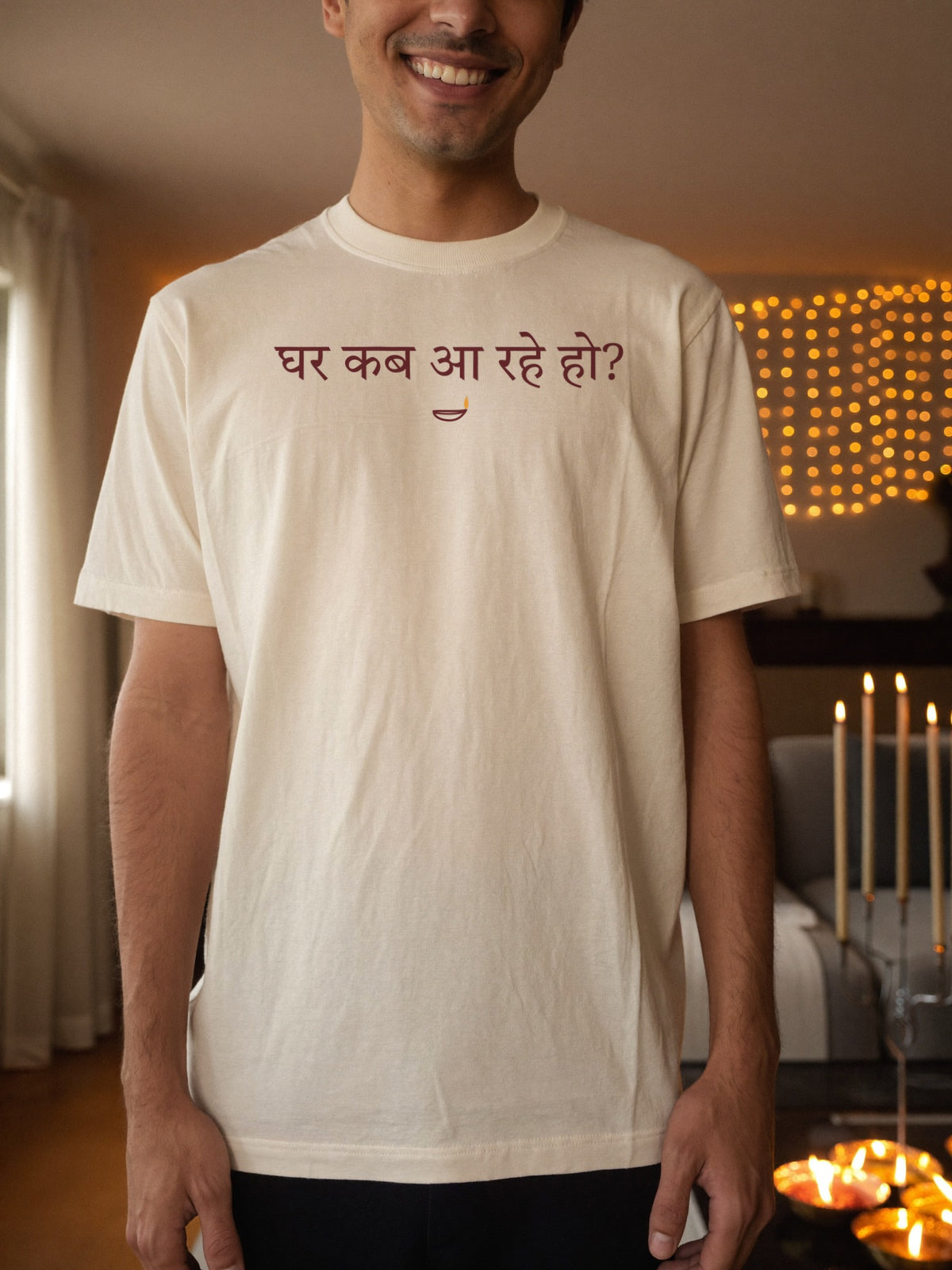 Man wearing the “घर कब आ रहे हो?” Hindi Diwali t-shirt with diya in off white by Halant, home before diwali